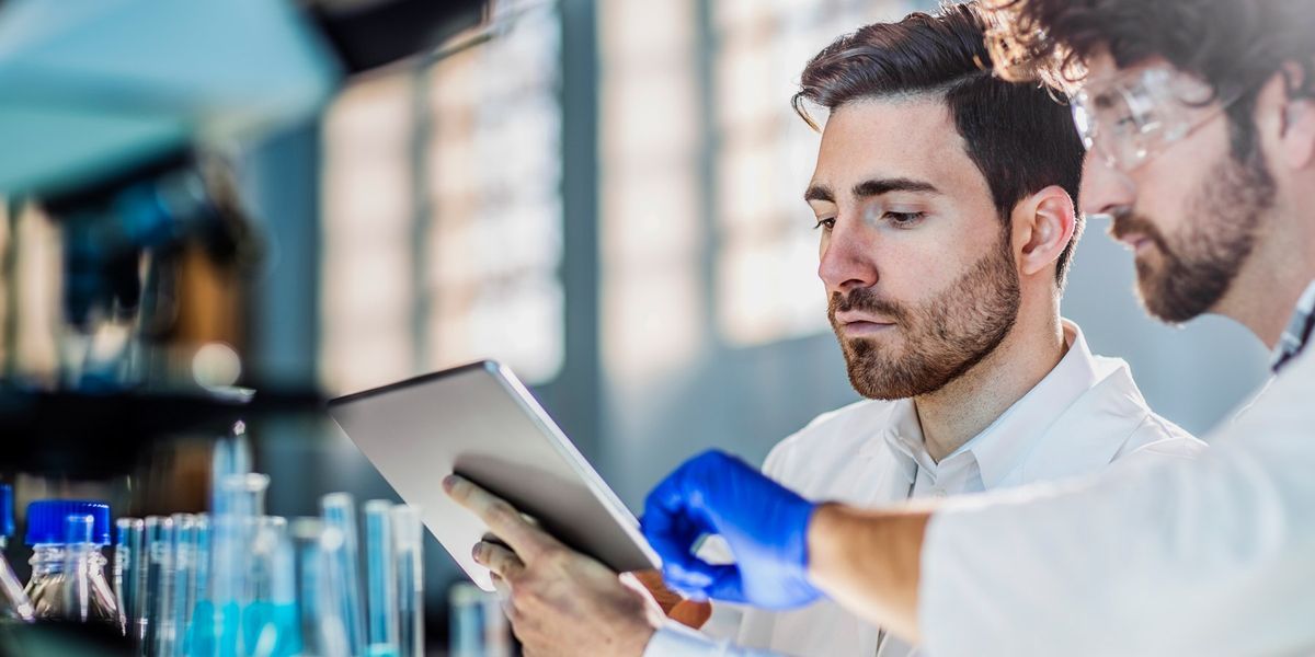 Two engineers examining data on a tablet