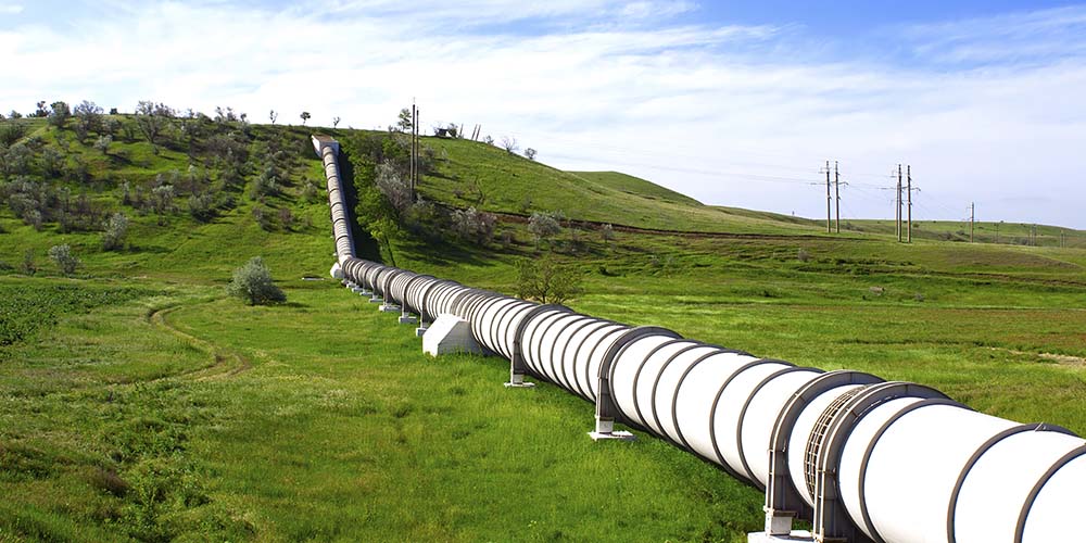 A natural gas pipeline crossing a field of green grass